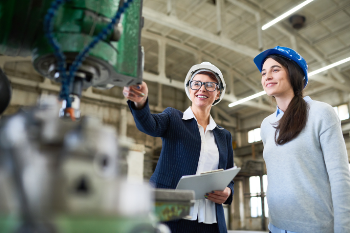 Two women assessing equipment and discussing capital efficiency.