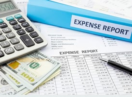 Expense report with calculator and cash.