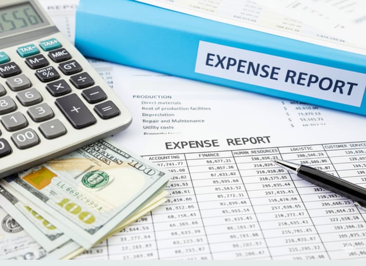 Expense report with calculator and cash.