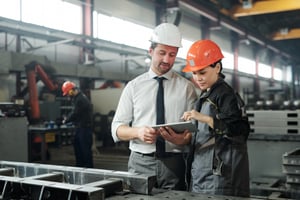 Line manager discussing capital allocation with an executive at the manufacturing plant.