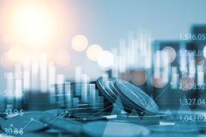 Stacks of coins with financial graphs and stock market data overlaid, symbolizing economic growth, investment, and business finance trends