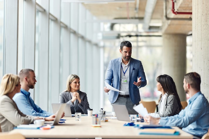 Male leader talking to his team about plans on a meeting in the office