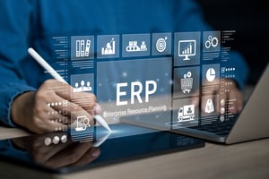 Person using a stylus and laptop with a digital interface displaying ERP  icons representing business functions such as analytics, supply chain, sales, and finance.