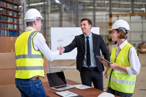 business meeting between manager and manufacturing employees discussing integrated payroll solutions