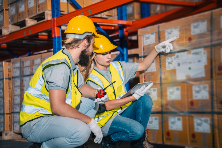 Two employees taking cost optimization into account as they take inventory in the warehouse