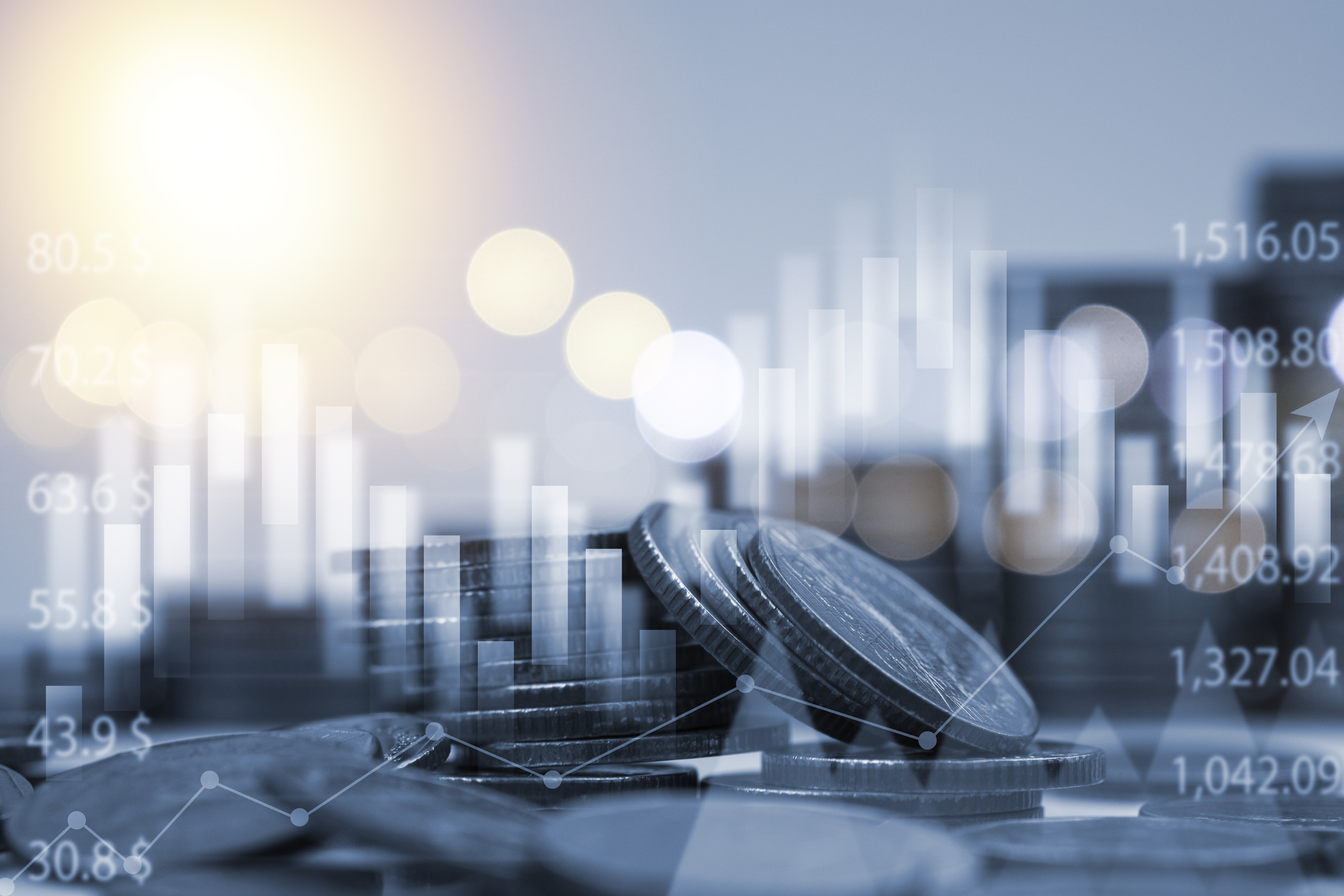Stacks of coins with financial graphs and stock market data overlaid, symbolizing economic growth, investment, and business finance trends