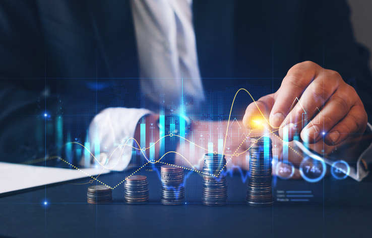 Businessman analyzing financial growth with stacked coins and rising graphs representing revenue and profit increase